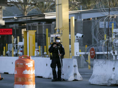 A Customs and Border Protection agent is seen wearing a face mask as a preventive measure to avoid the spread of COVID-19 coronavirus, at San Ysidro crossing from Tijuana, Baja California state, Mexico, on April 23, 2020, on the U.S.-Mexico border.