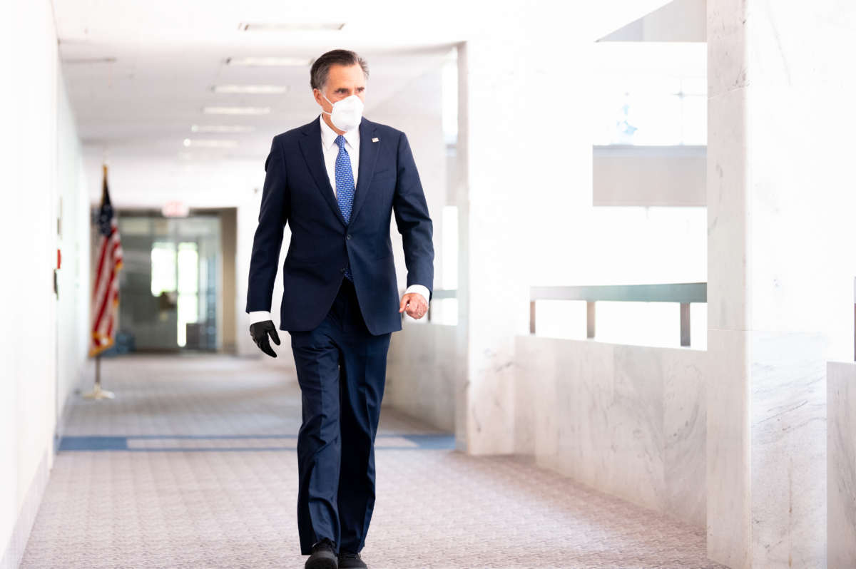 Sen. Mitt Romney walks towards the Republican caucus launch.