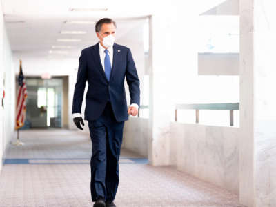 Sen. Mitt Romney walks towards the Republican caucus launch.