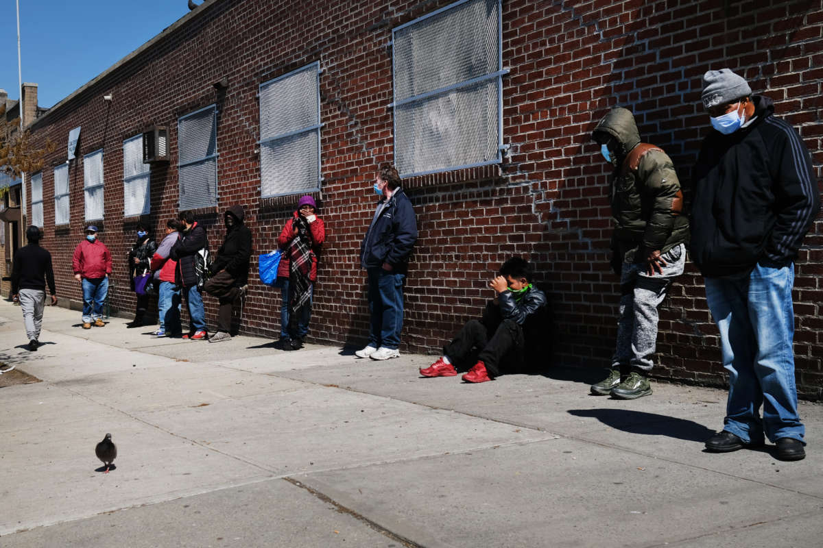 People wait in line to receive food at a food bank on April 28, 2020, in the Brooklyn borough of New York City.