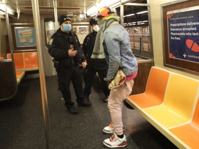 Police escort individuals sleeping on trains out of the cars as the New York City subway system, the largest public transportation system in the nation, is closed for nightly cleaning due to the continued spread of the coronavirus on May 7, 2020, in New York City.