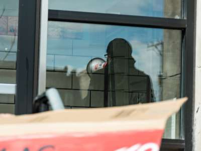 A reflection of a person speaking into a megaphone