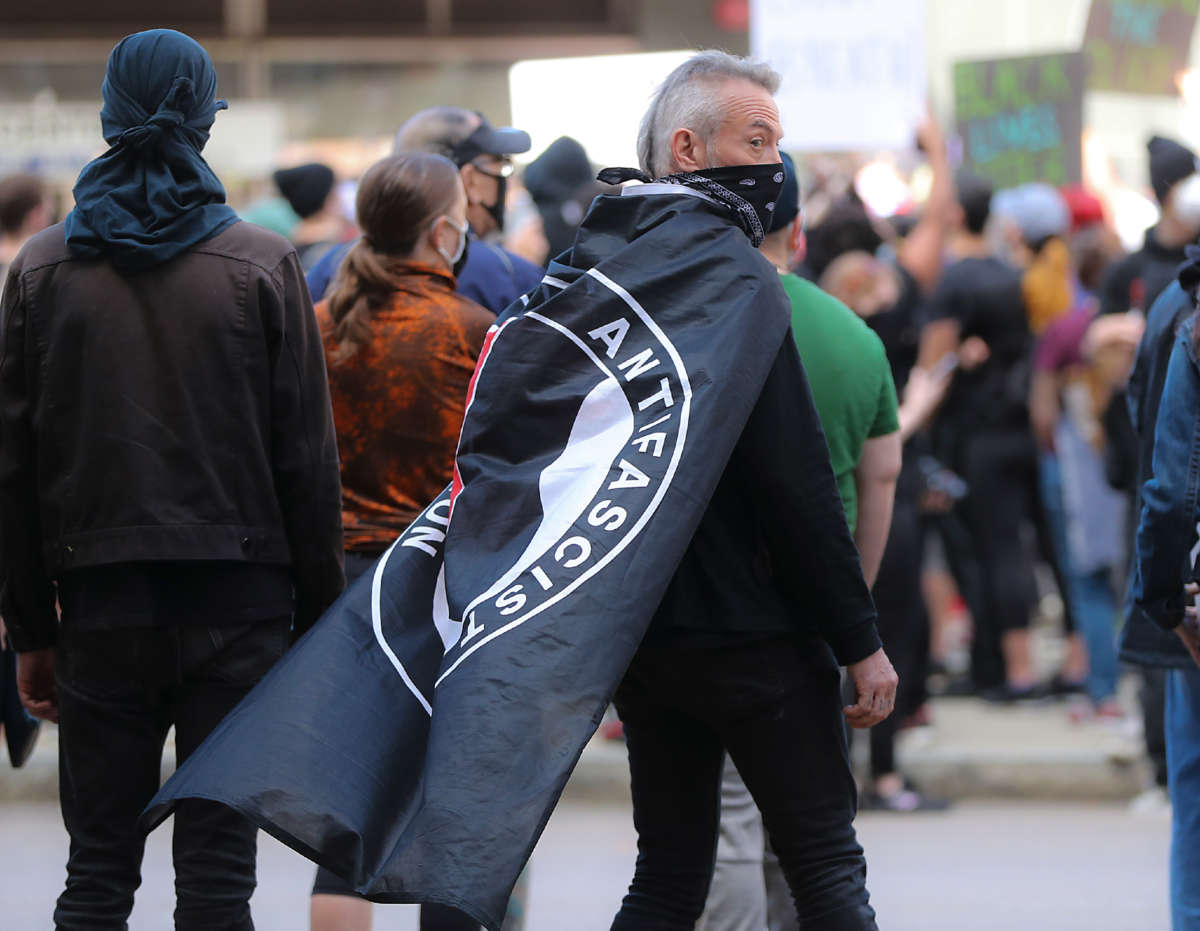 Hundreds of protesters gather at Government Center including a protester with an ANTIFA flag draped over his shoulders during a rally sponsored by the Youth of Greater Boston to demand justice for George Floyd and support of the Black Lives Matter movement in Boston on May 31, 2020.