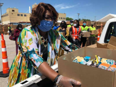 Ella M. Jones, pictured in May 2020, loads a box into a truck at a volunteer food distribution site.