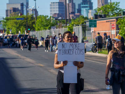 Protesters march and hold signs during a demonstration in a call for justice for George Floyd who died while in custody of the Minneapolis police, on May 30, 2020, by the 5th police precinct in Minneapolis, Minnesota.