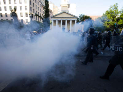 Police officers wearing riot gear push back demonstrators while shooting tear gas next to St. John's Episcopal Church outside of the White House, June 1, 2020, in Washington D.C., during a protest over the death of George Floyd.