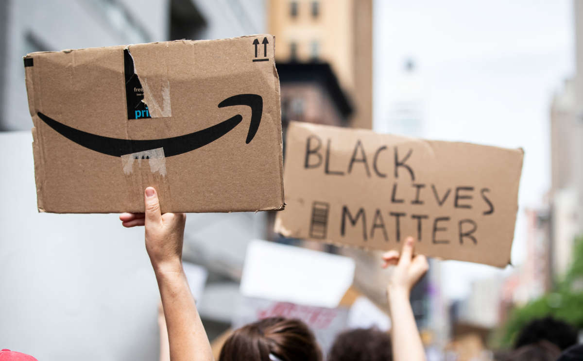 The back of a protesters sign has the Amazon logo next to another protesters sign that says "Black Lives Matter" in the Manhattan Borough of New York on June 2, 2020.