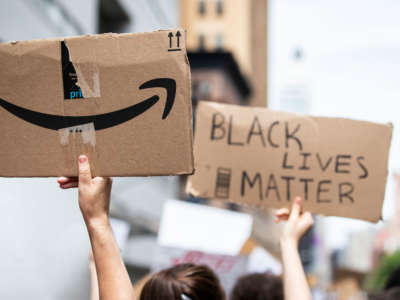 The back of a protesters sign has the Amazon logo next to another protesters sign that says "Black Lives Matter" in the Manhattan Borough of New York on June 2, 2020.