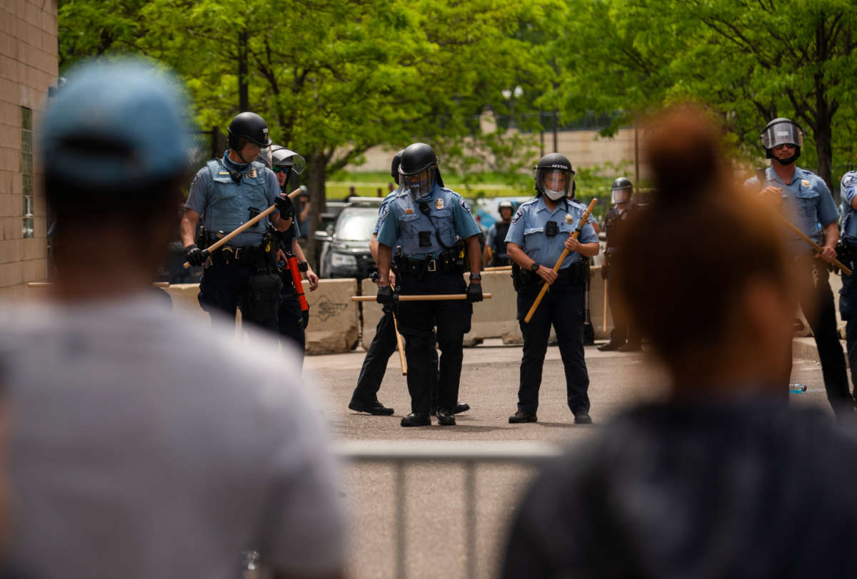 Police officers stand in a line while facing protesters outside the Third Police Precinct on May 27, 2020, in Minneapolis, Minnesota.