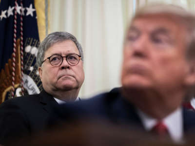 Attorney General William Barr stands behind President Trump in the Oval Office of the White House on November 26, 2019, in Washington, D.C.