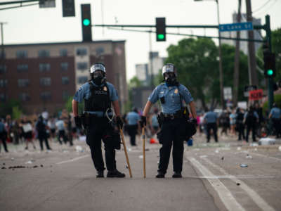 Two police officers stand outside the Third Police Precinct during protests on May 27, 2020, in Minneapolis, Minnesota.