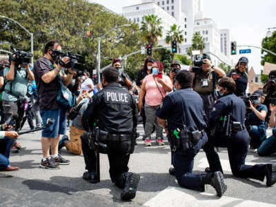 LAPD officers take a knee with clergy and marchers at LAPD Headquarters during a demonstration demanding justice for George Floyd on June 2, 2020, in Los Angeles, California.