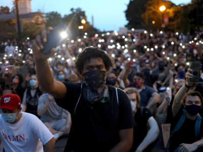Demonstrators sing "Lean On Me" near the White House during a peaceful protest against police brutality and the death of George Floyd, on June 3, 2020, in Washington, D.C.