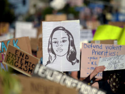 Protesters march holding placards and a portrait of Breonna Taylor during a demonstration against racism and police brutality, in Hollywood, California, on June 7, 2020.