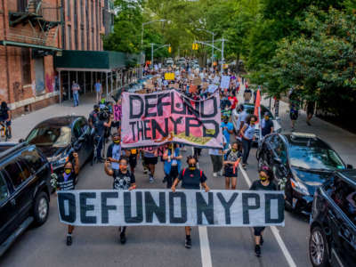 Protesters march down the streets of Williamsburg, New York, behind a giant Defund NYPD banner, June 7, 2020.