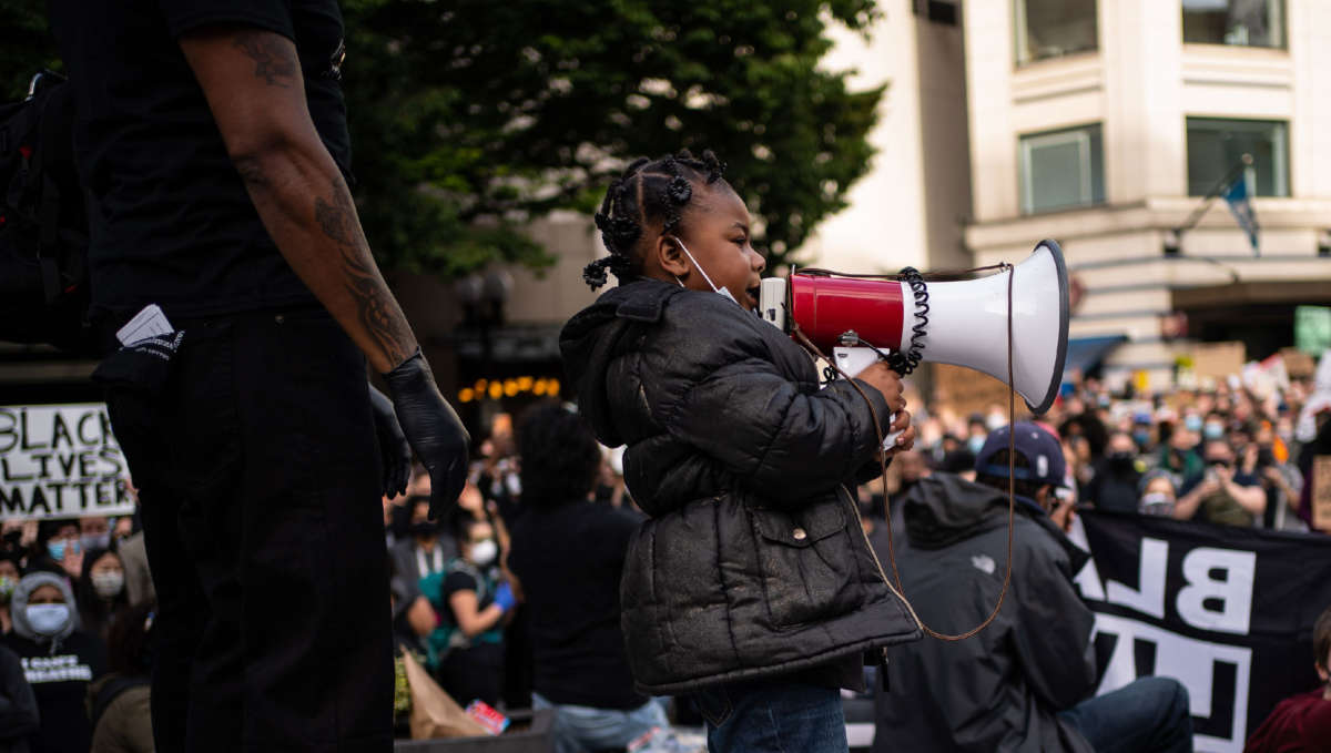 A child leads chants from the stage as Black Lives Matter protesters rally at Westlake Park before marching through the downtown area on June 14, 2020, in Seattle, Washington.