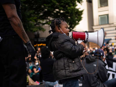 A child leads chants from the stage as Black Lives Matter protesters rally at Westlake Park before marching through the downtown area on June 14, 2020, in Seattle, Washington.