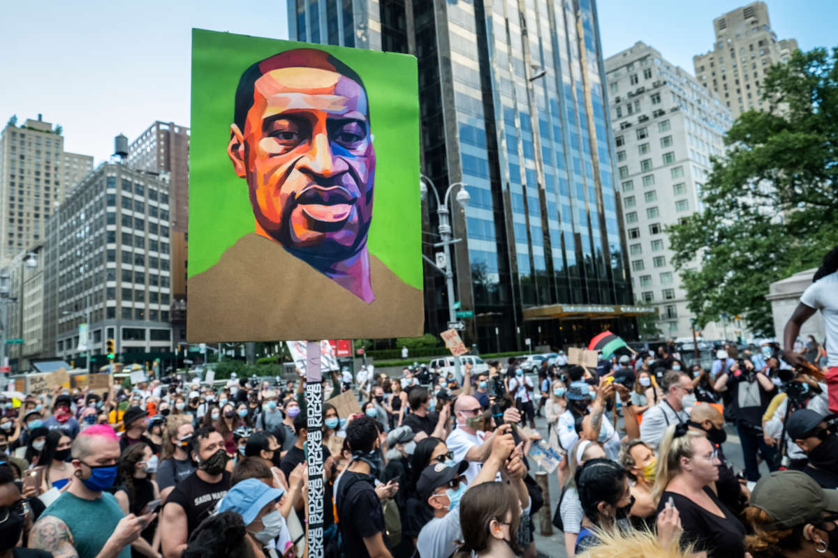 A painting of George Floyd is displayed at a massive protest