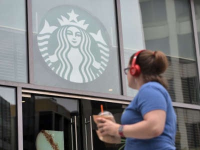 A woman looks up at a starbuck's logo