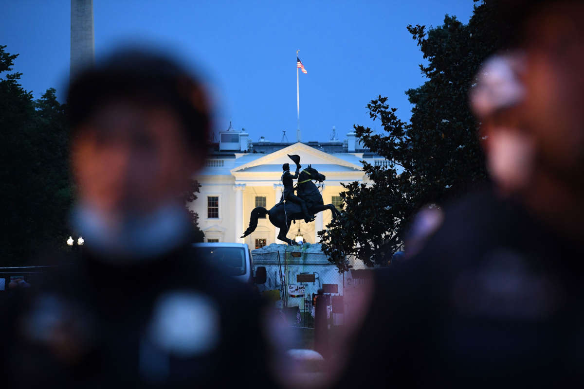 A row of police officers stand guard with the equestrian statue of former President Andrew Jackson behind, after protesters tried to topple it, at Lafayette square, in front of the White House, in Washington, D.C., on June 22, 2020.