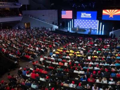 People fill the rows of a church as donald trump speaks onstage