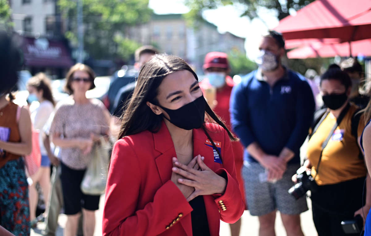 Rep. Alexandria Ocasio-Cortez speaks with a voter near a polling station during the New York primaries Election Day on June 23, 2020, in New York City.