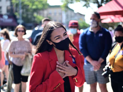 Rep. Alexandria Ocasio-Cortez speaks with a voter near a polling station during the New York primaries Election Day on June 23, 2020, in New York City.