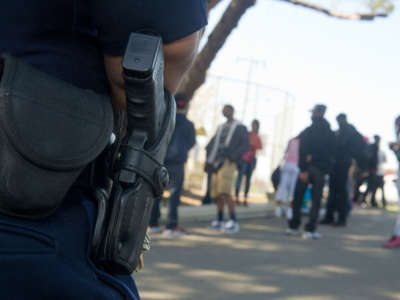 Oakland School Police Officer H. Matthews watches students on their way out of school as classes let out for the day on March 12, 2013, in Oakland, California.