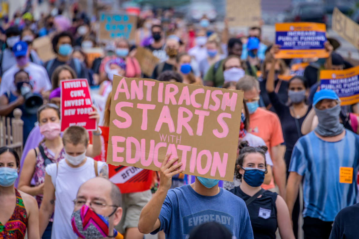 A participant holds a sign at a march from Brooklyn Borough Hall to the Defund The Police Occupation at City Hall.