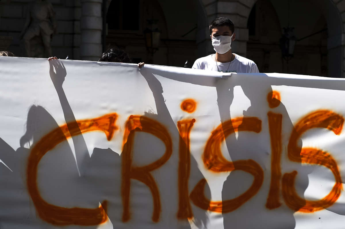 Protesters hold a section of a banner reading "Crisis" during a Fridays for future demonstration, a worldwide climate strike against governmental inaction towards climate breakdown and environmental pollution.