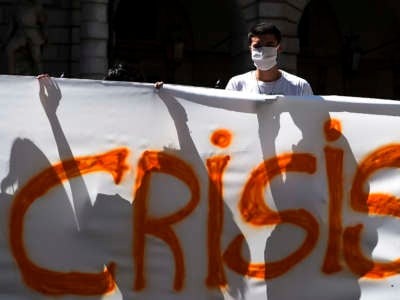 Protesters hold a section of a banner reading "Crisis" during a Fridays for future demonstration, a worldwide climate strike against governmental inaction towards climate breakdown and environmental pollution.