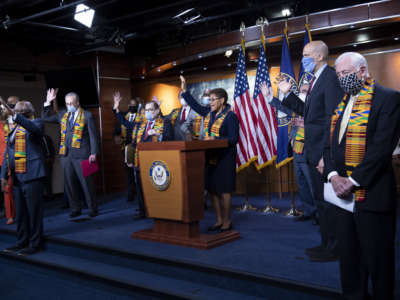 Democratic members of Congress raise their hands in response to a reporters question during a press conference to unveil policing reform and equal justice legislation in Washington on June 8, 2020.