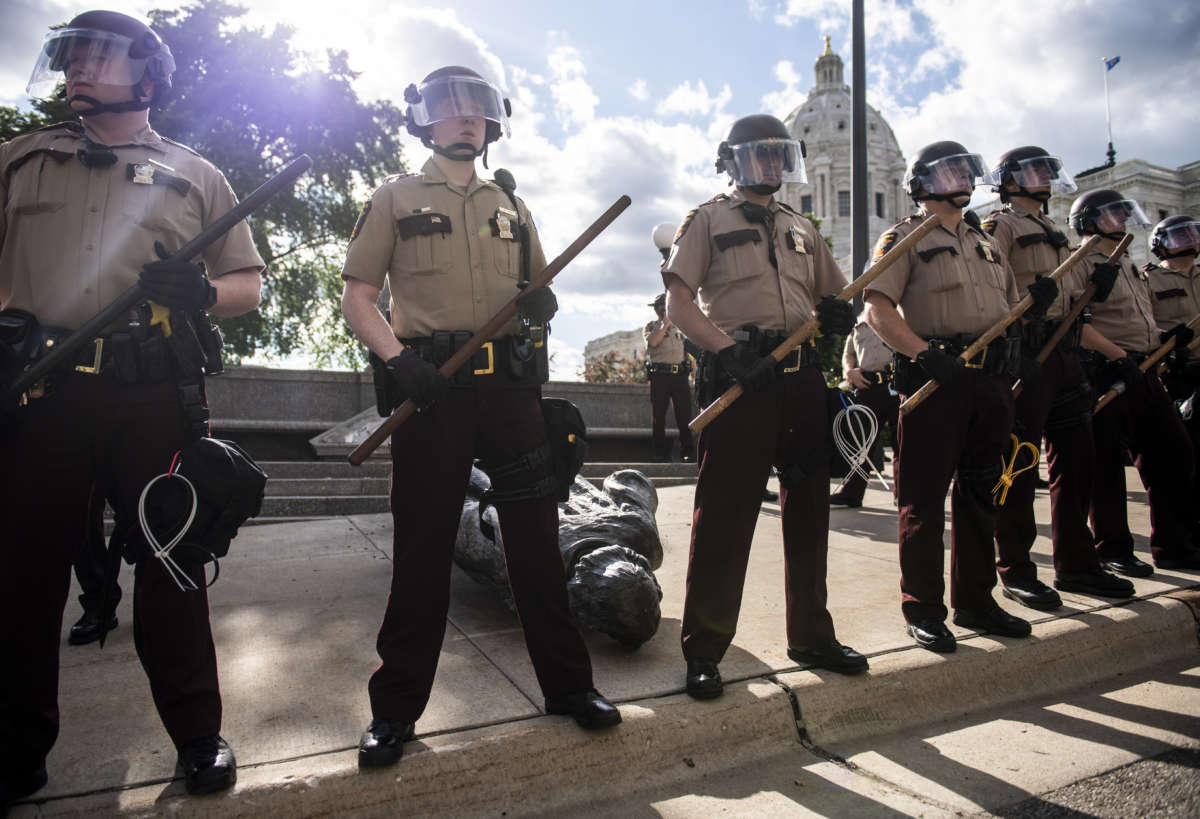 Members of the Minnesota State Patrol stand guard over a statue of Christopher Columbus which was toppled to the ground by protesters on the grounds of the State Capitol on June 10, 2020, in St. Paul, Minnesota.