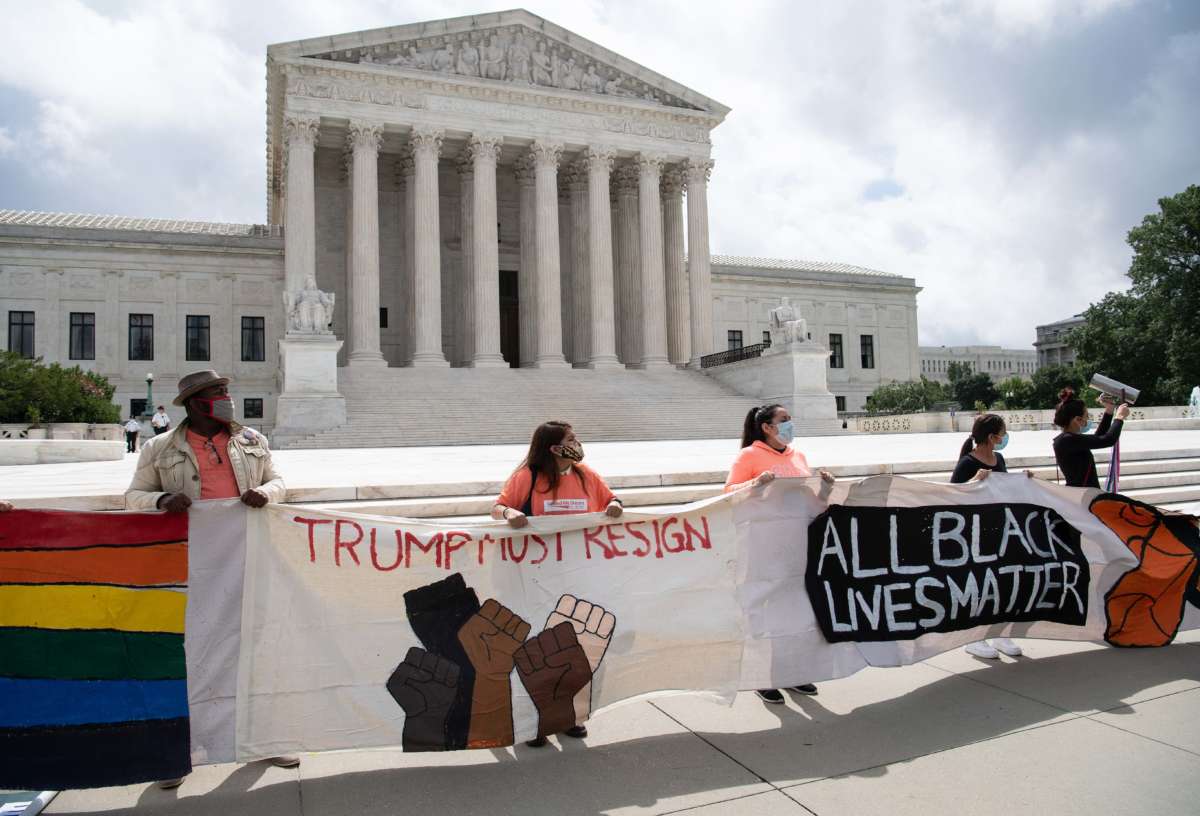 Activists hold banners in front of the U.S. Supreme Court in Washington, D.C., on June 18, 2020.