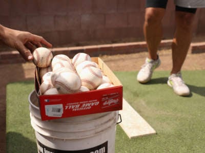 Baseballs are taken from a box as MLB pitchers practice in a backyard throwing session on June 5, 2020, in Scottsdale, Arizona.