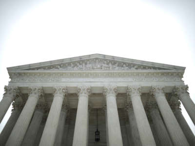 The SCOTUS building stands against a grey sky