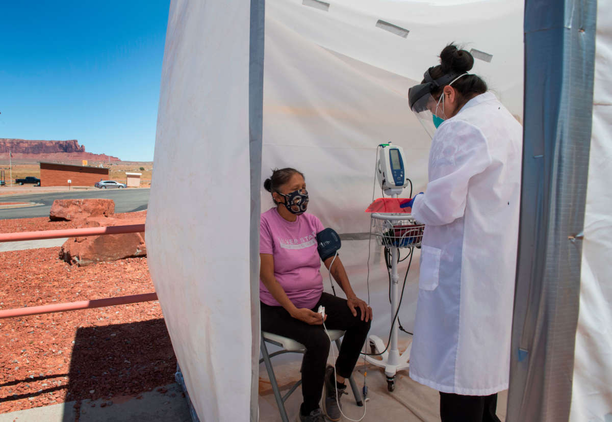 A nurse checks vitals from a Navajo woman complaining of virus symptoms, at a COVID-19 testing center at the Navajo Nation town of Monument Valley in Arizona on May 21, 2020.