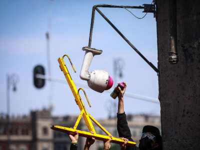 A man paints a security camera during a protest against police brutality in Mexico City, Mexico, on June 8, 2020.
