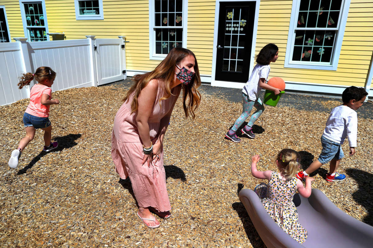 Preschool teacher Jenna Grenier keeps an eye on the children playing in the outside play area at Magical Beginnings Learning Academy in Middleton, Massachusetts, on May 22, 2020.