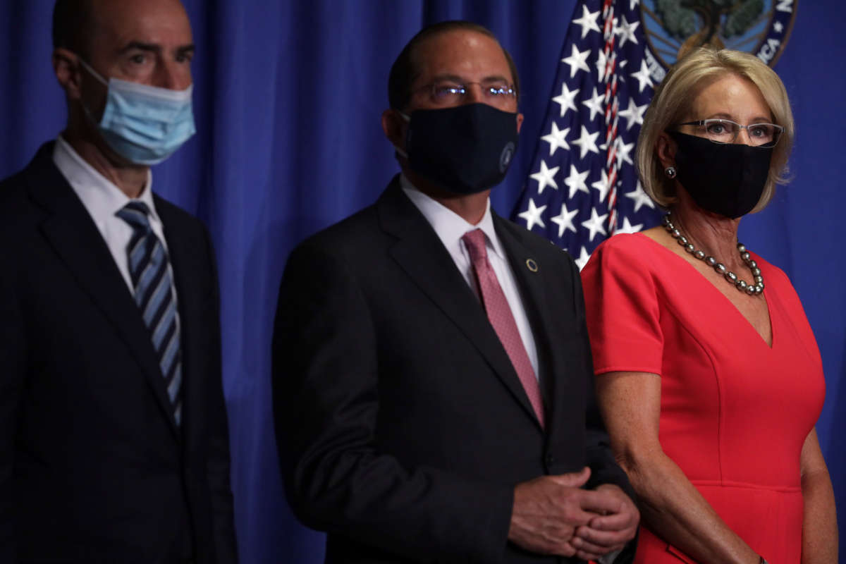 From right, U.S. Secretary of Education Betsy DeVos, Secretary of Health and Human Services Alex Azar, and Secretary of Labor Eugene Scalia listen during a White House Coronavirus Task Force press briefing at the U.S. Department of Education, July 8, 2020, in Washington, D.C.