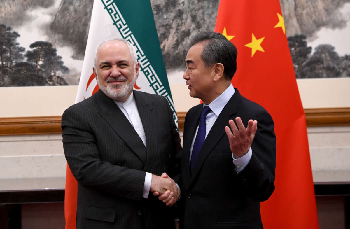 China's Foreign Minister Wang Yi shakes hands with Iran's Foreign Minister Mohammad Javad Zarif during a meeting at the Diaoyutai State Guesthouse on December 31, 2019, in Beijing, China.