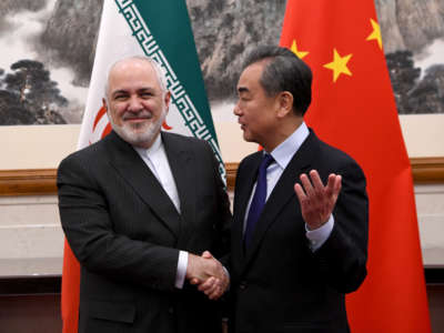 China's Foreign Minister Wang Yi shakes hands with Iran's Foreign Minister Mohammad Javad Zarif during a meeting at the Diaoyutai State Guesthouse on December 31, 2019, in Beijing, China.