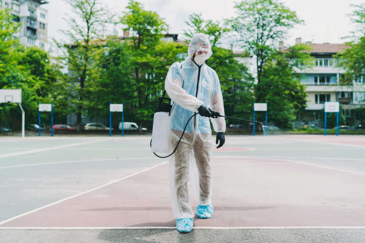 A person disinfects a basketball court.
