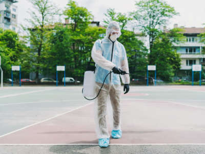 A person disinfects a basketball court.