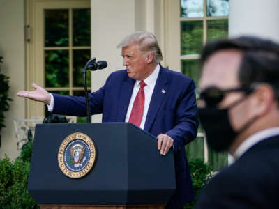 Donald Trump gestures while standing at a podium