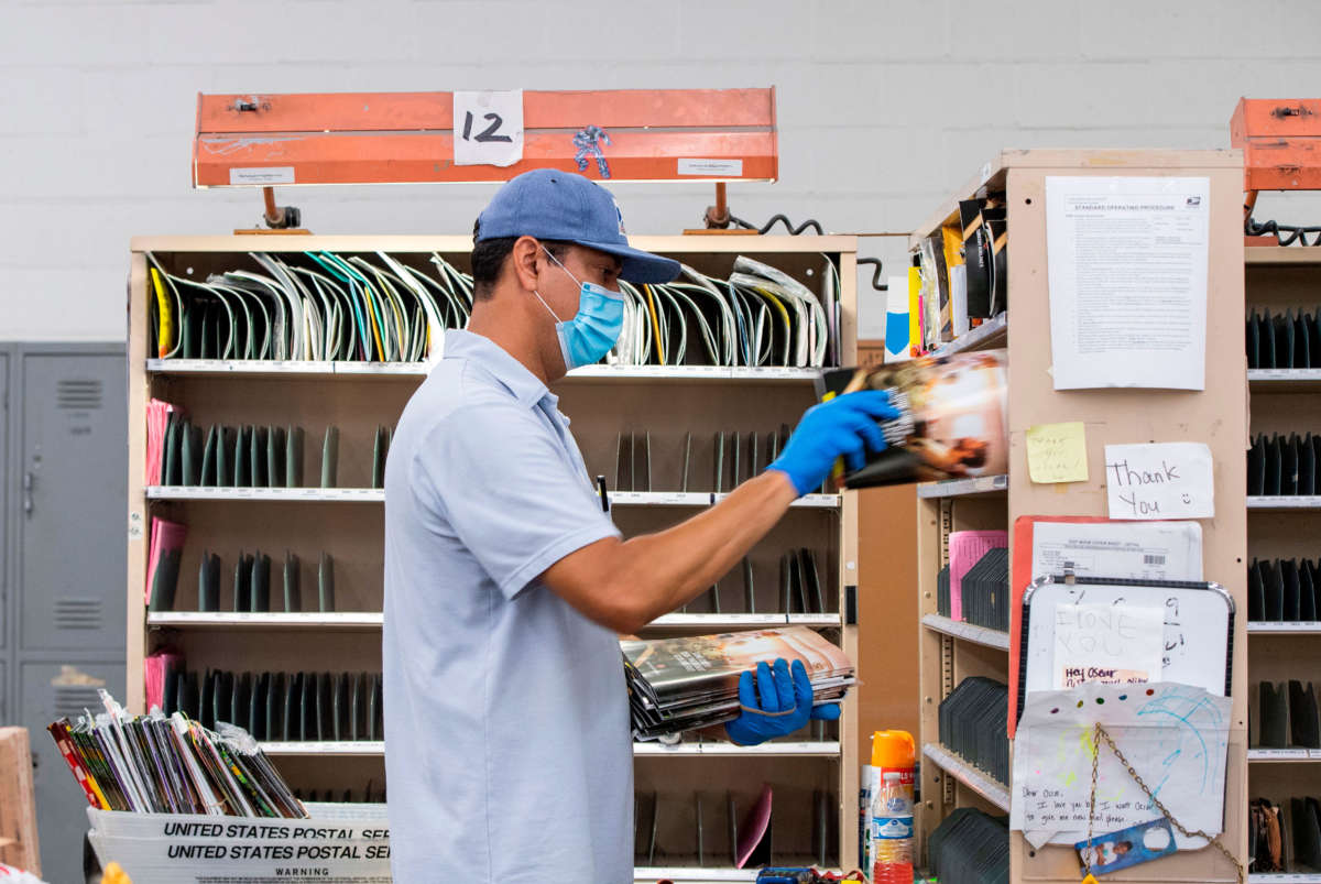 Mail carrier Oscar Osorio delivers mail in Los Feliz amid the COVID-19 pandemic on April 29, 2020, in Los Angeles, California.