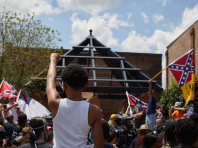 Anti-racist protesters raise fists toward supporters of the Confederacy at the Alamance County Courthouse at a rally with the Burlington-Alamance March For Justice and Community in Graham, North Carolina, on July 11, 2020.