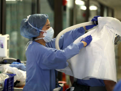 A nurse helps a doctor remove his personal protective equipment after leading a team that performed a procedure on a COVID-19 patient in the intensive care unit at Regional Medical Center on May 21, 2020, in San Jose, California.