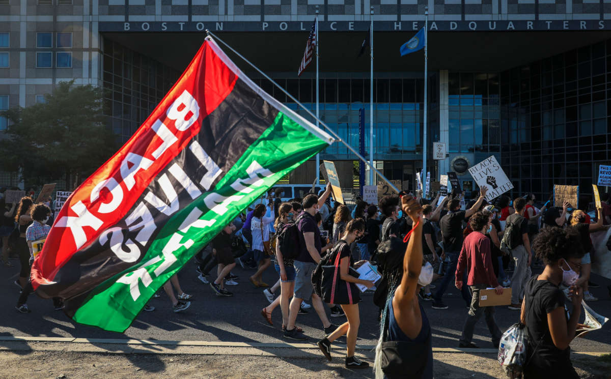 A demonstrator holds a pan-African "Black Lives Matter" flag as more than 1,000 people gather on July 4, 2020, to celebrate the lives of Black women and demand an end to police violence.