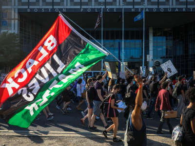 A demonstrator holds a pan-African "Black Lives Matter" flag as more than 1,000 people gather on July 4, 2020, to celebrate the lives of Black women and demand an end to police violence.